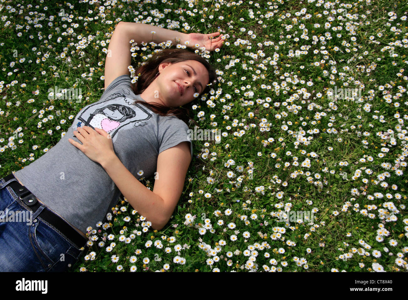 Young woman laying in flowers Stock Photo