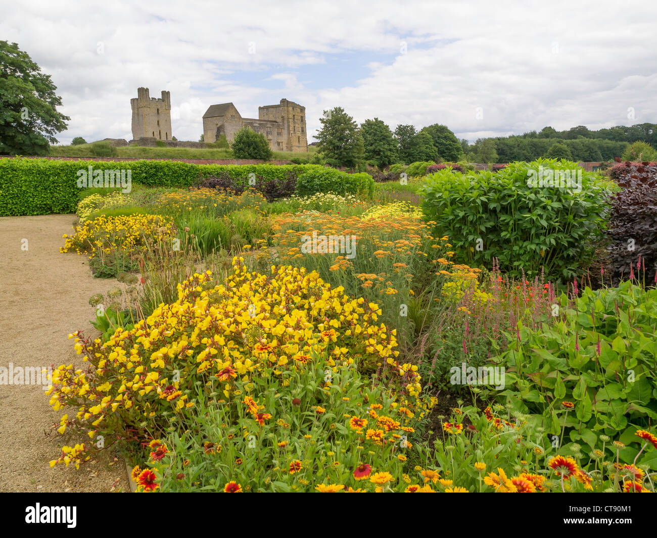 Helmsley Castle overlooking the Helmsley Walled Garden with a show of summer flowers Stock Photo