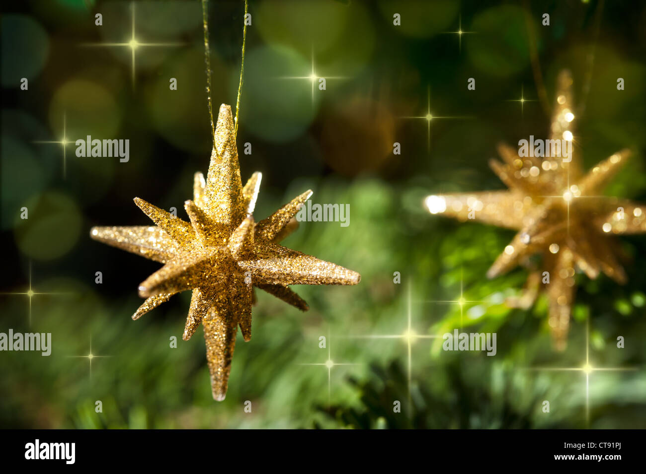 Decorative Gold Star ornament in a Christmas tree in front of a glitter ...