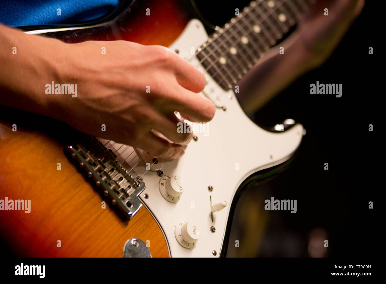 Man play guitar with zoomed long bony fingers Stock Photo