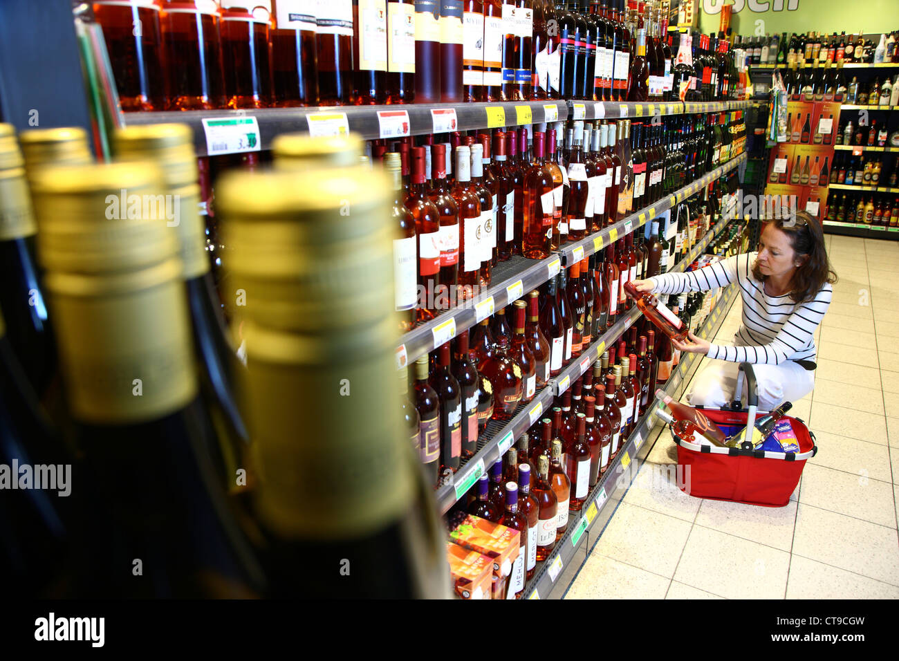 Woman is shopping in a large supermarket. Beverage department
