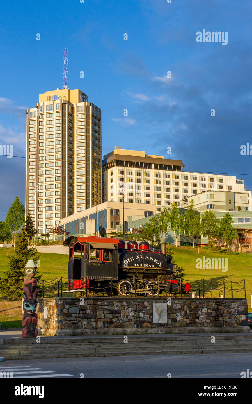 Alaska Railroad historical train statue with downtown Anchorage, Alaska, hotels in background. Stock Photo