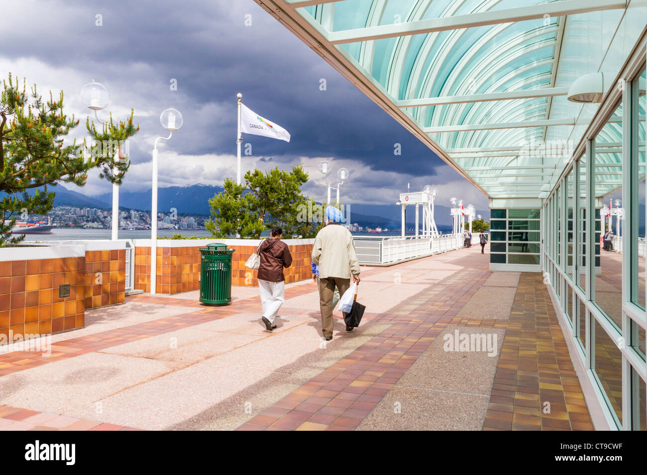 Tourists enjoying Canada Place entertainment center and Cruise Ship Terminal at Vancouver Harbor, British Columbia, Canada. Stock Photo