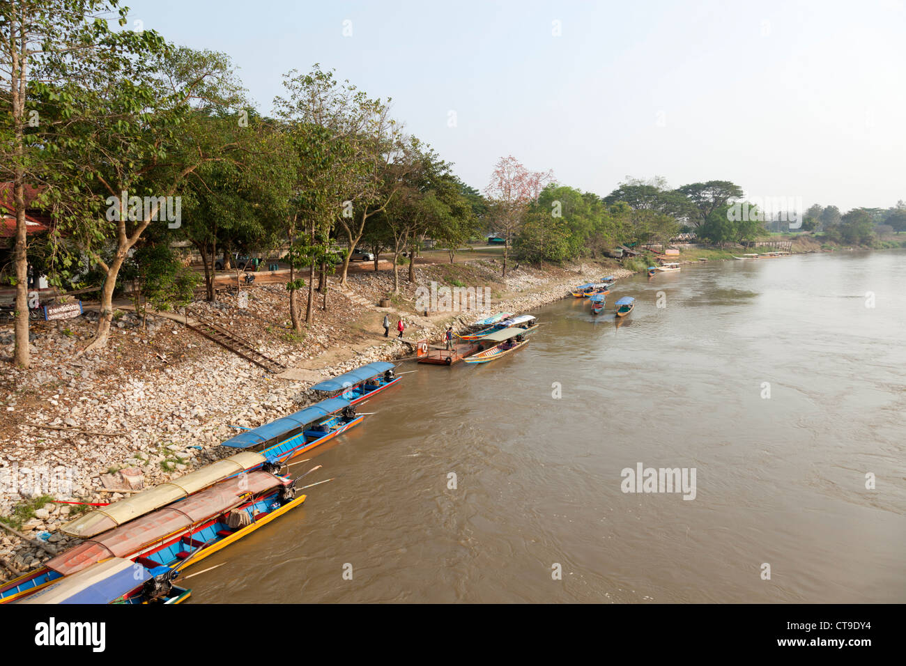 Long tail boats moored on a bank of the Kok river, at Chiang Rai (Thailand). Bateaux à longue queue sur la rivière Kok. Stock Photo