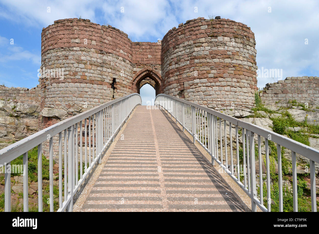 Beeston Castle ruins of inner ward gatehouse modern footbridge across deep ditch to arched entrance at summit of 500ft high crag above Cheshire Plain Stock Photo