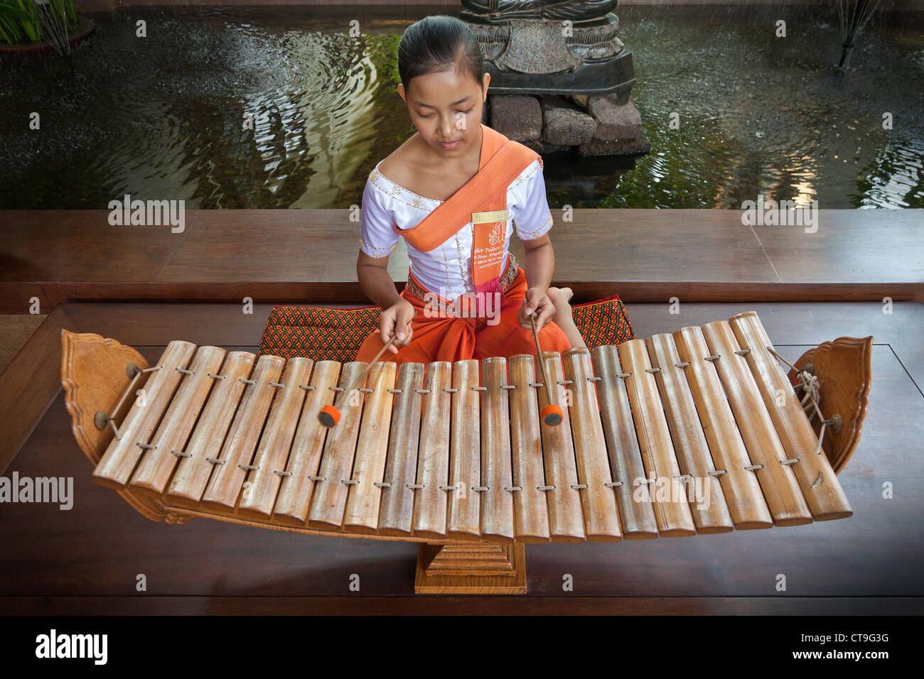 Roneat-ek is a xylophone used in Khmer classical music. Being played by young Cambodian woman. Stock Photo