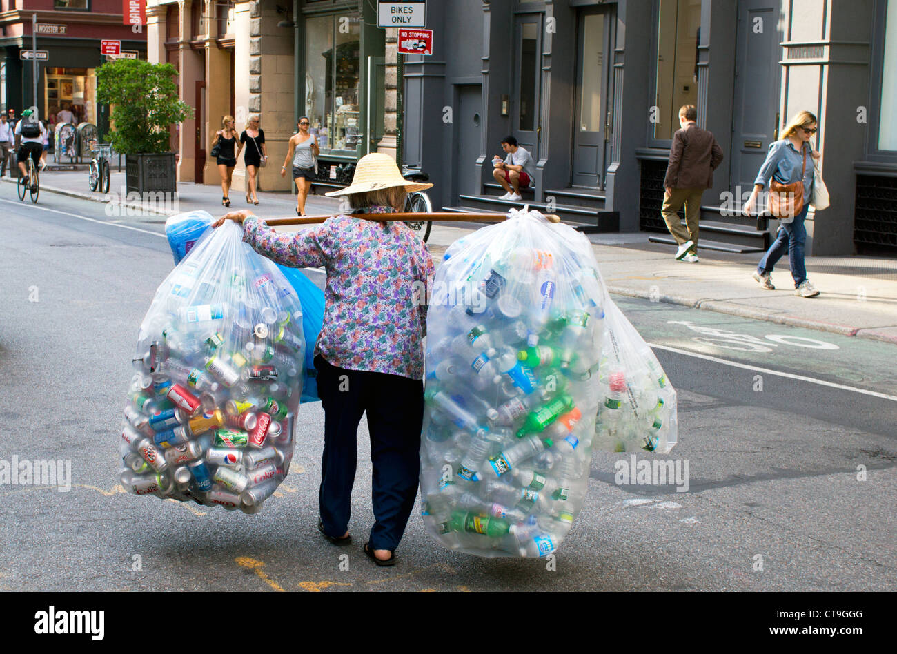 Elderly Asian woman collecting cans and bottles for the deposit to