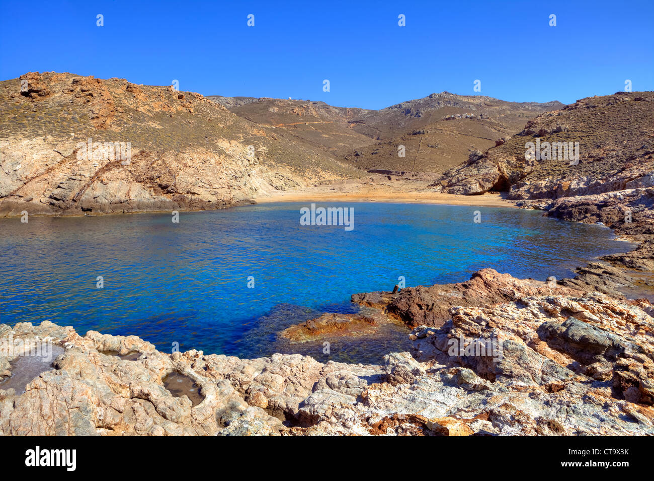 secluded bays with crystal clear water and shale in the north-east of Mykonos, Greece Stock Photo