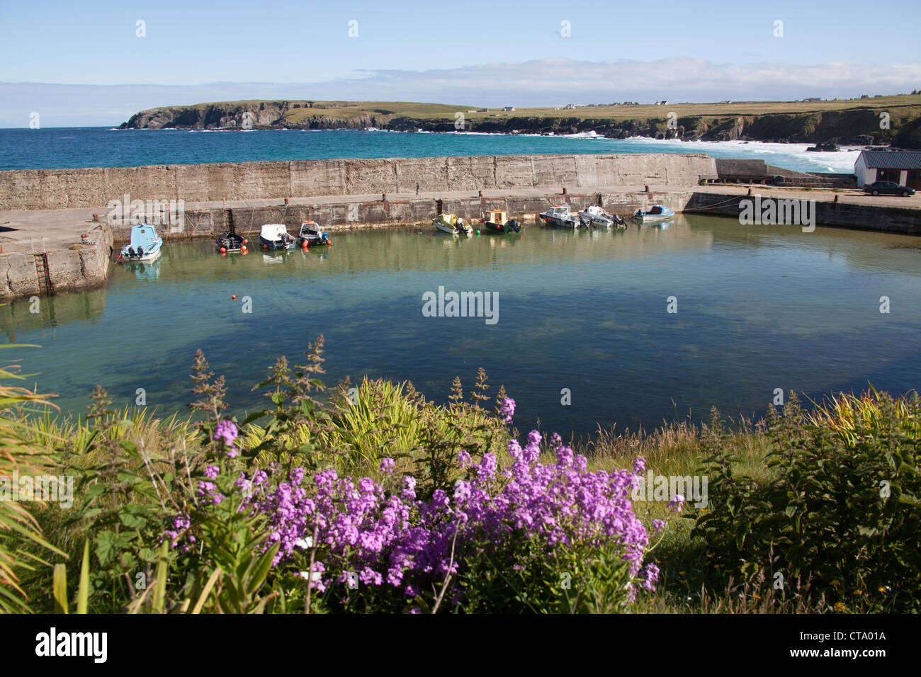 Isle of Lewis, Scotland. Small fishing boats tied up alongside the picturesque Port Nis Harbour. Stock Photo