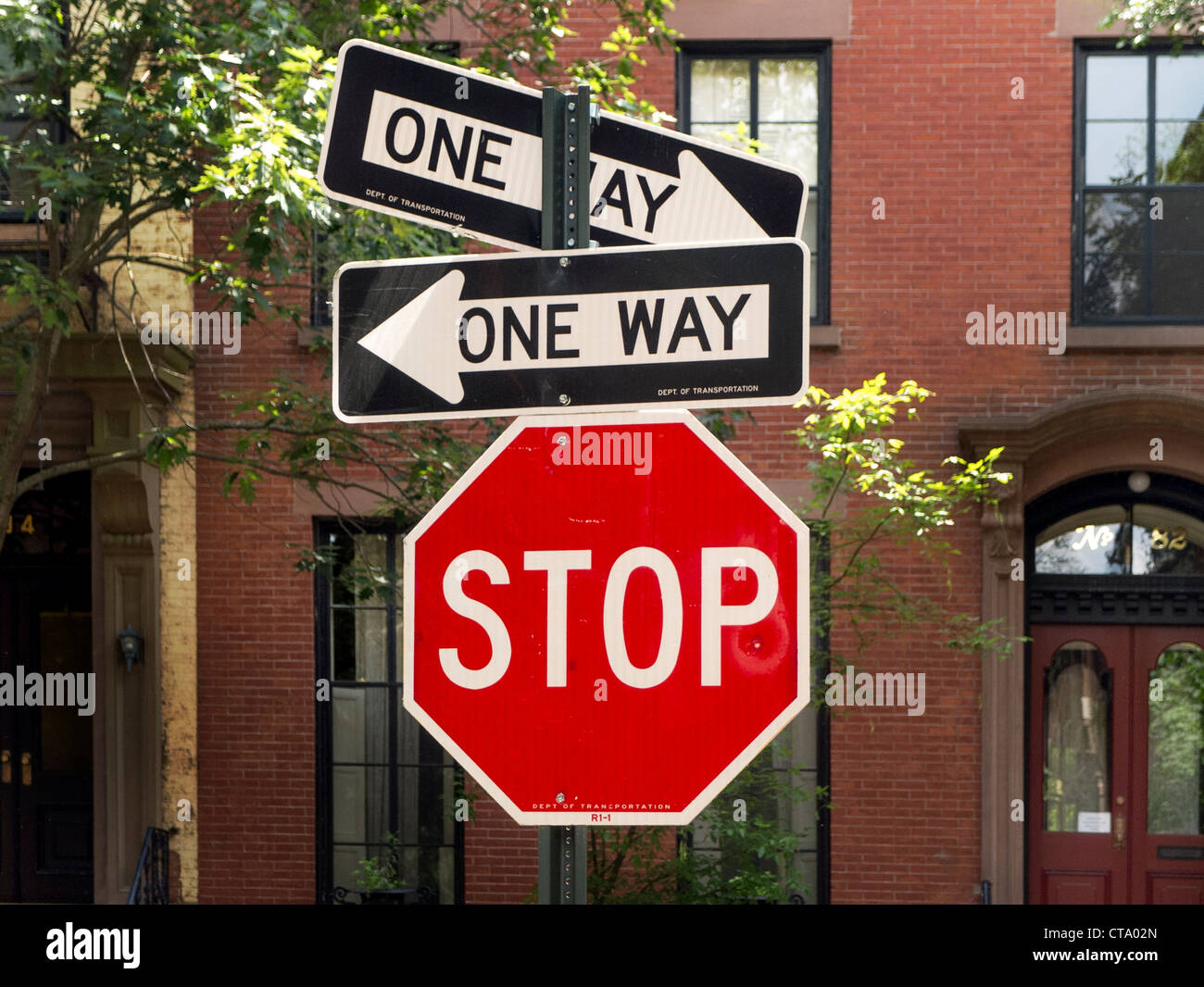 One-way street signs pointing in opposite directions contradict each other at an intersection on Brooklyn Heights, New York City Stock Photo