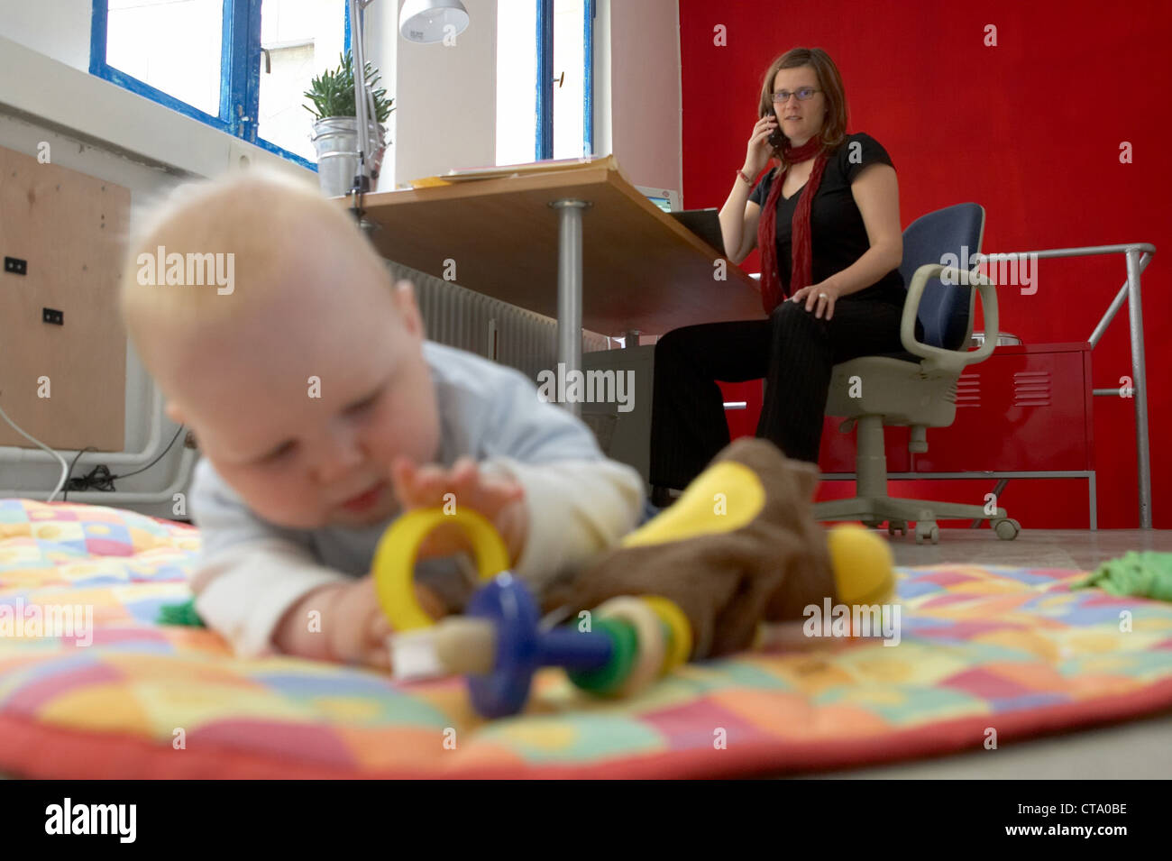 Berufstaetige mother with baby in office Stock Photo