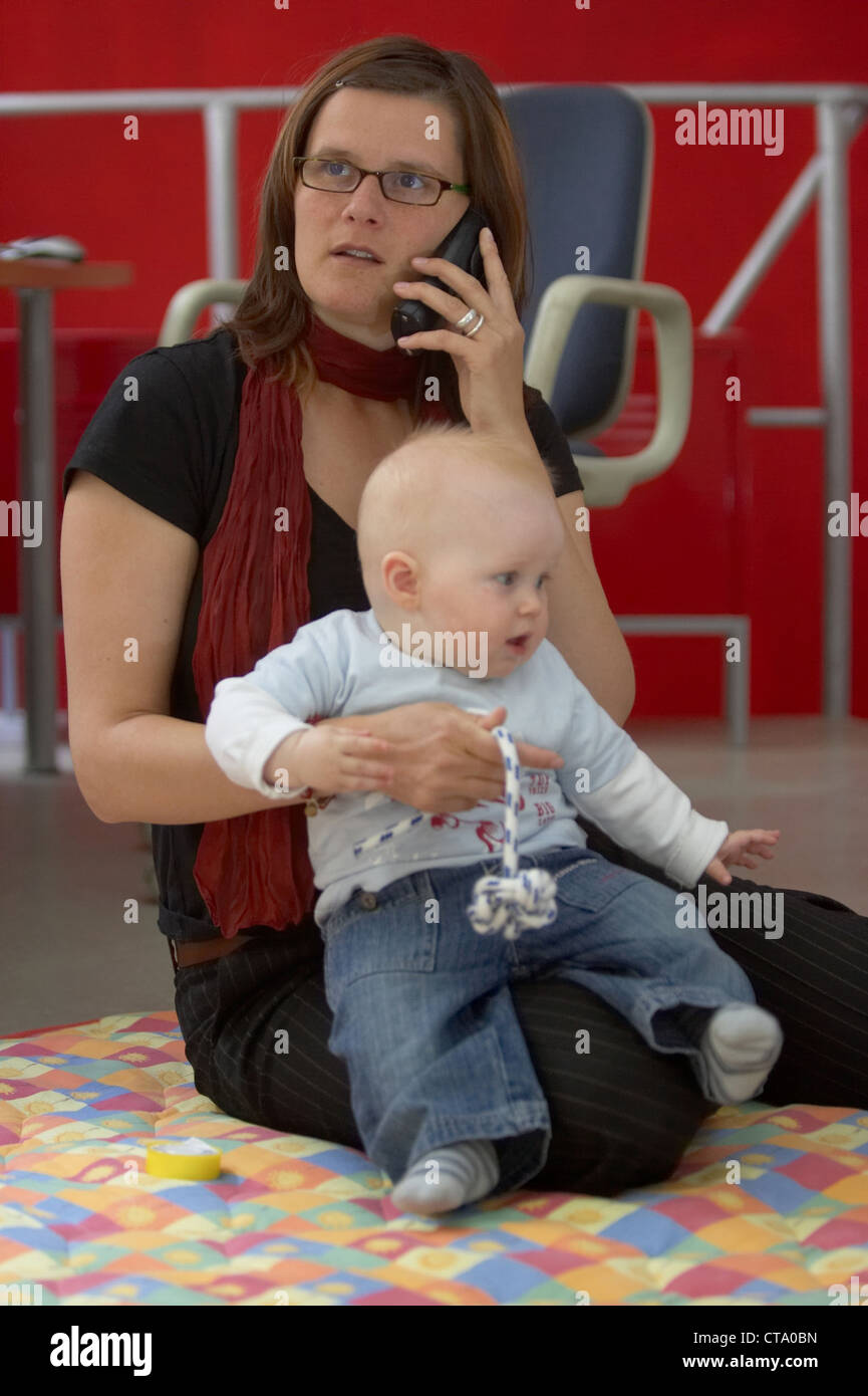 Berufstaetige mother with baby in office Stock Photo