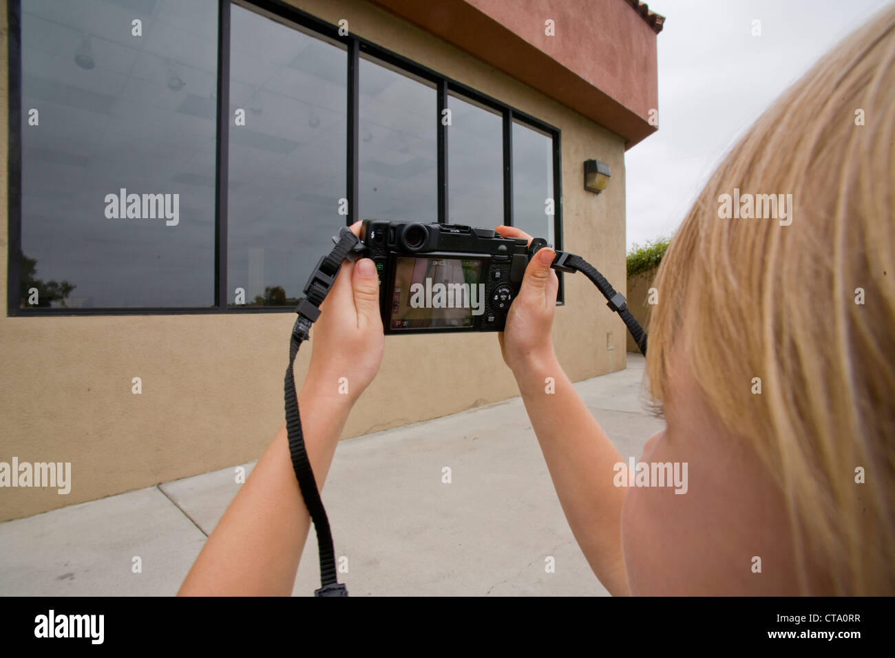 Sixyearold girl uses a digital camera to photography the windows of