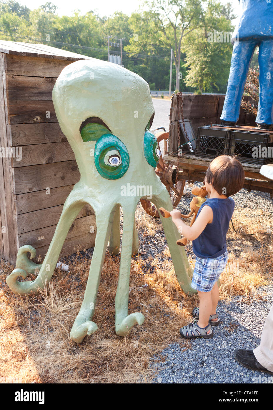 A boy inspecting a humorous model of an octopus Stock Photo