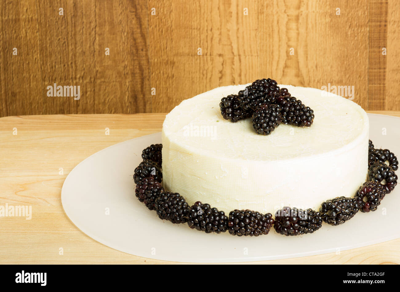 A block of white cheddar cheese with blackberries Stock Photo