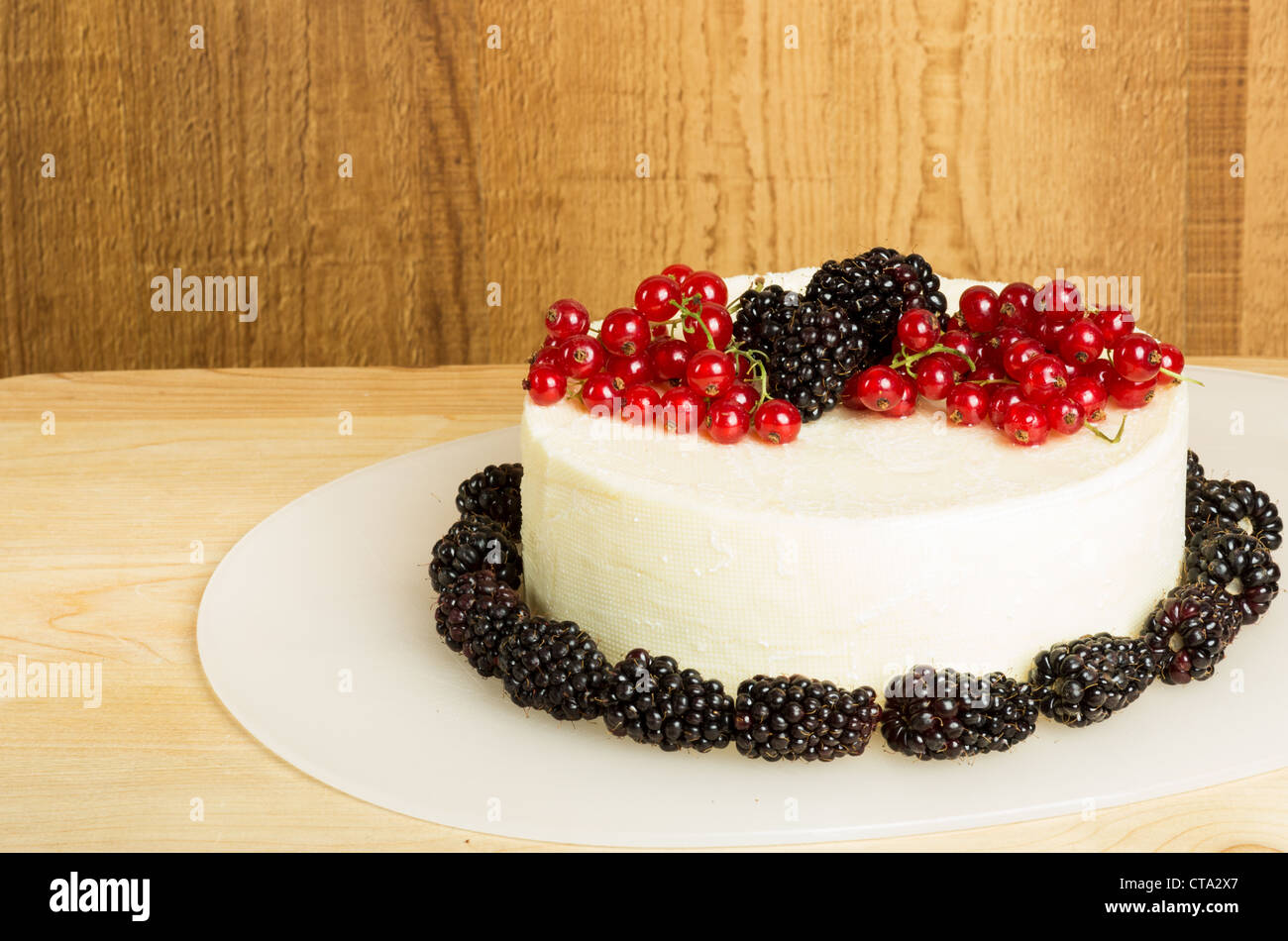 White cheddar cheese garnished with currants and blackberries Stock Photo