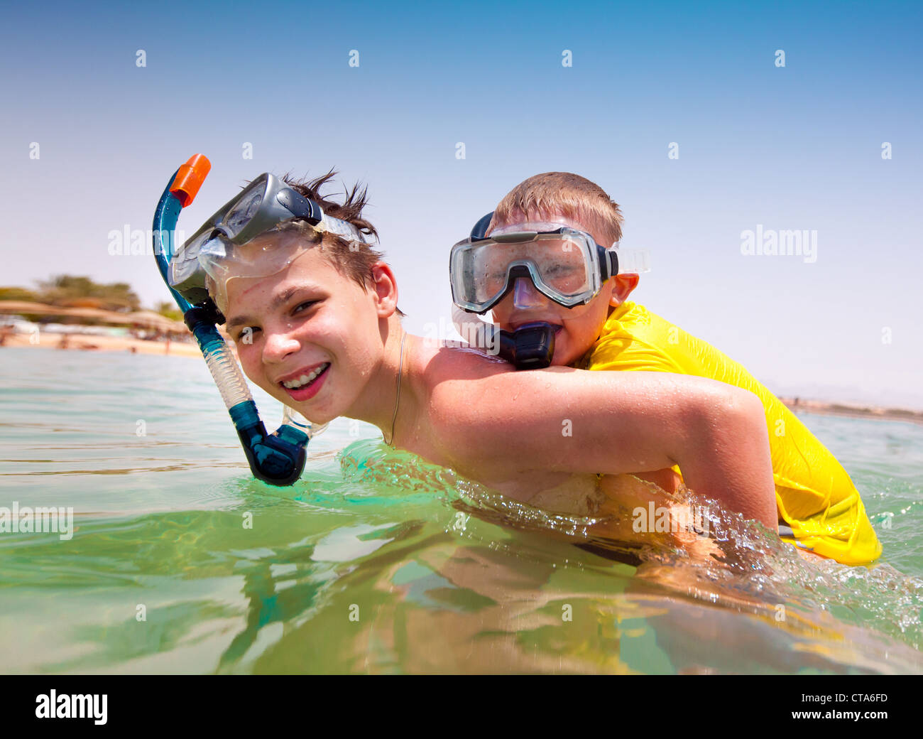 Two boys in the sea on a beach Stock Photo - Alamy