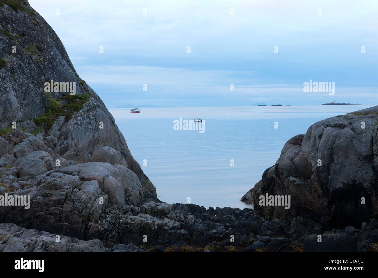 View towards the sea with fishing boats and rocky landscape in the morning light, Austvagoy, Lofoten, Nordland, Norway, Scandina Stock Photo