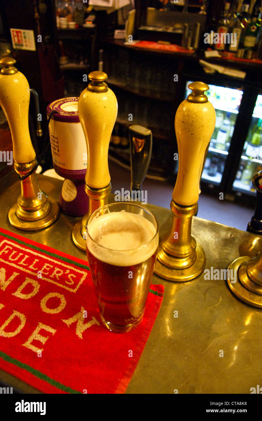 A pint of ale, beer on the bar at the The Grenadier pub, Wilton Row, Belgravia, London, at dusk, pub table drinks glasses Stock Photo