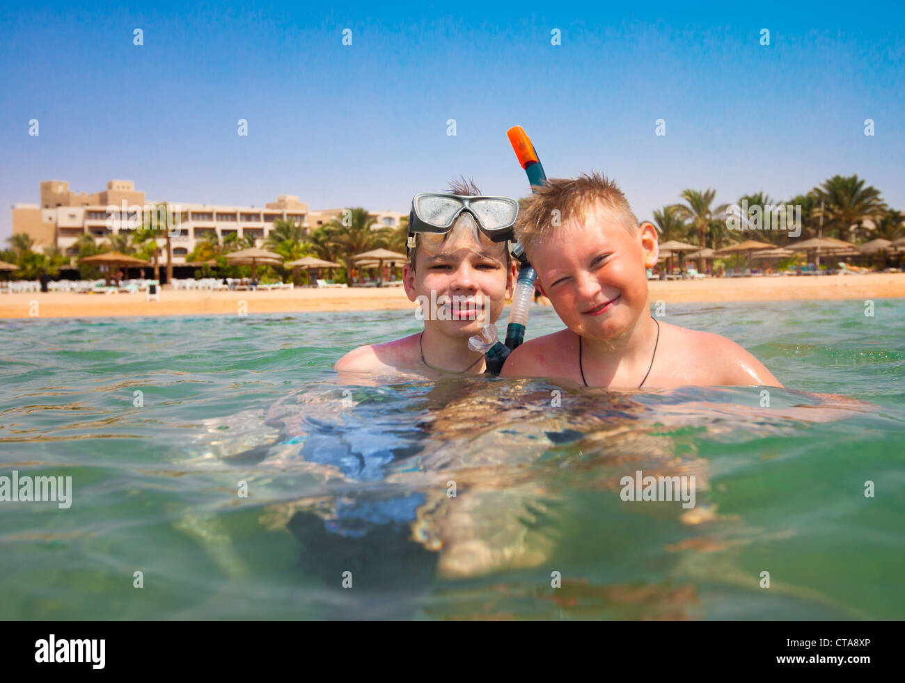 Two boys in the sea on a beach Stock Photo - Alamy