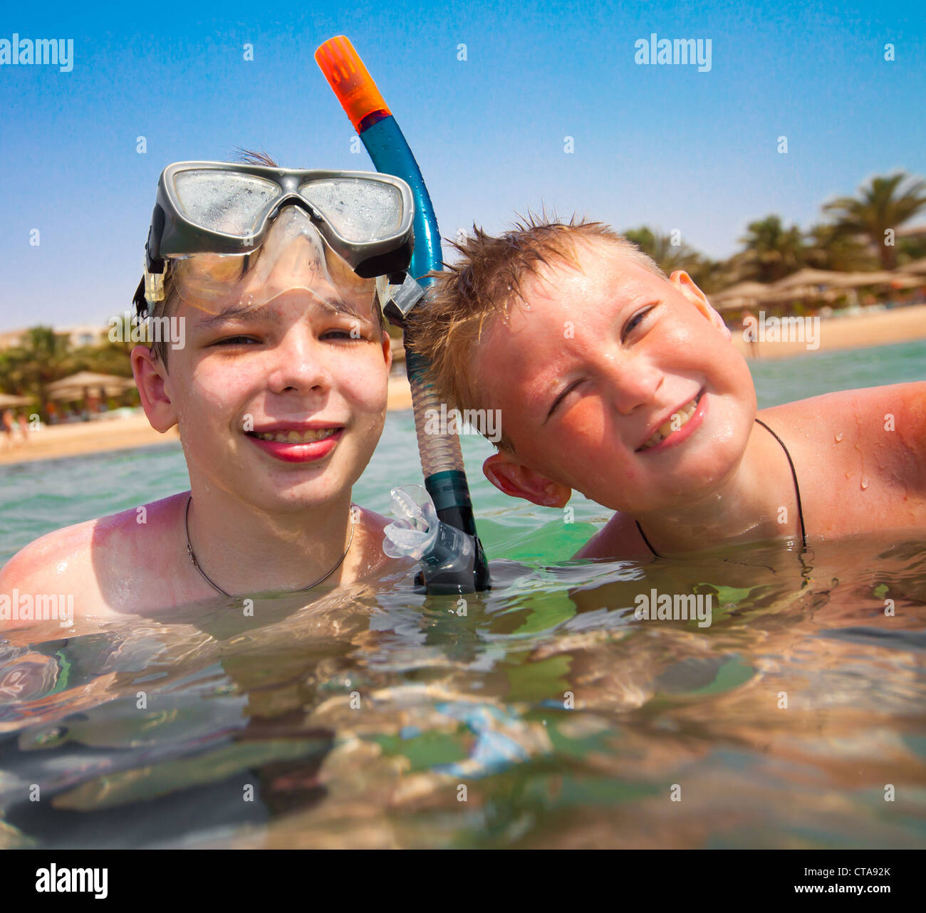 Two boys in the sea on a beach Stock Photo - Alamy