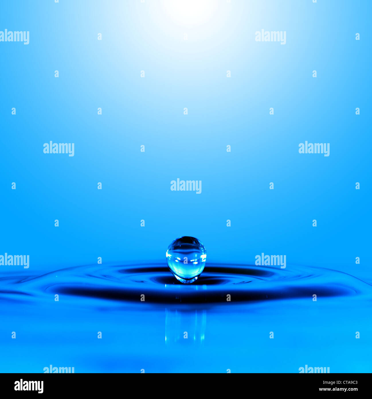 Falling drop of blue water Stock Photo - Alamy