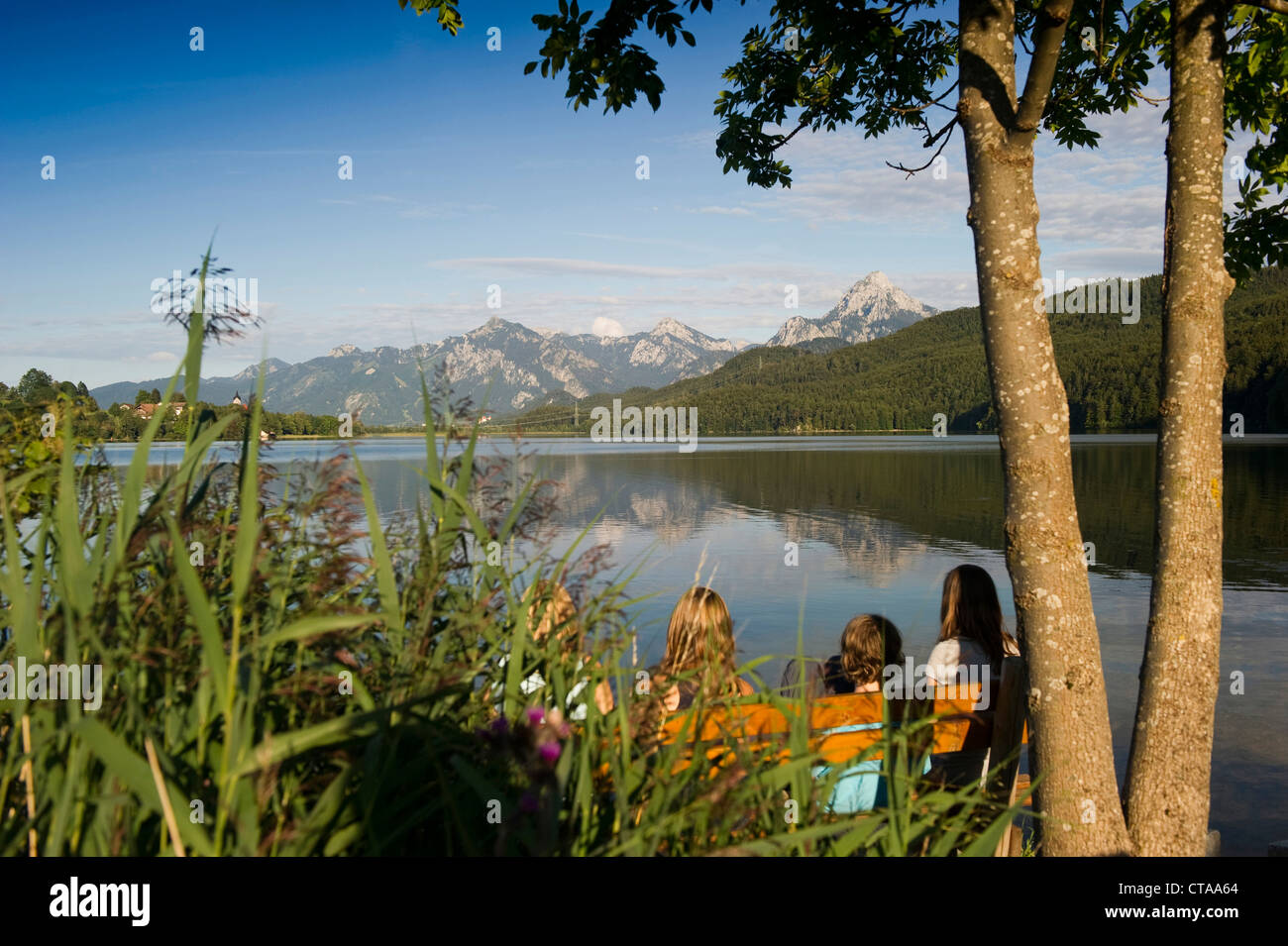 Children looking over lake Weissensee to mountain scenery, Fuessen, Allgaeu, Bavaria, Germany Stock Photo