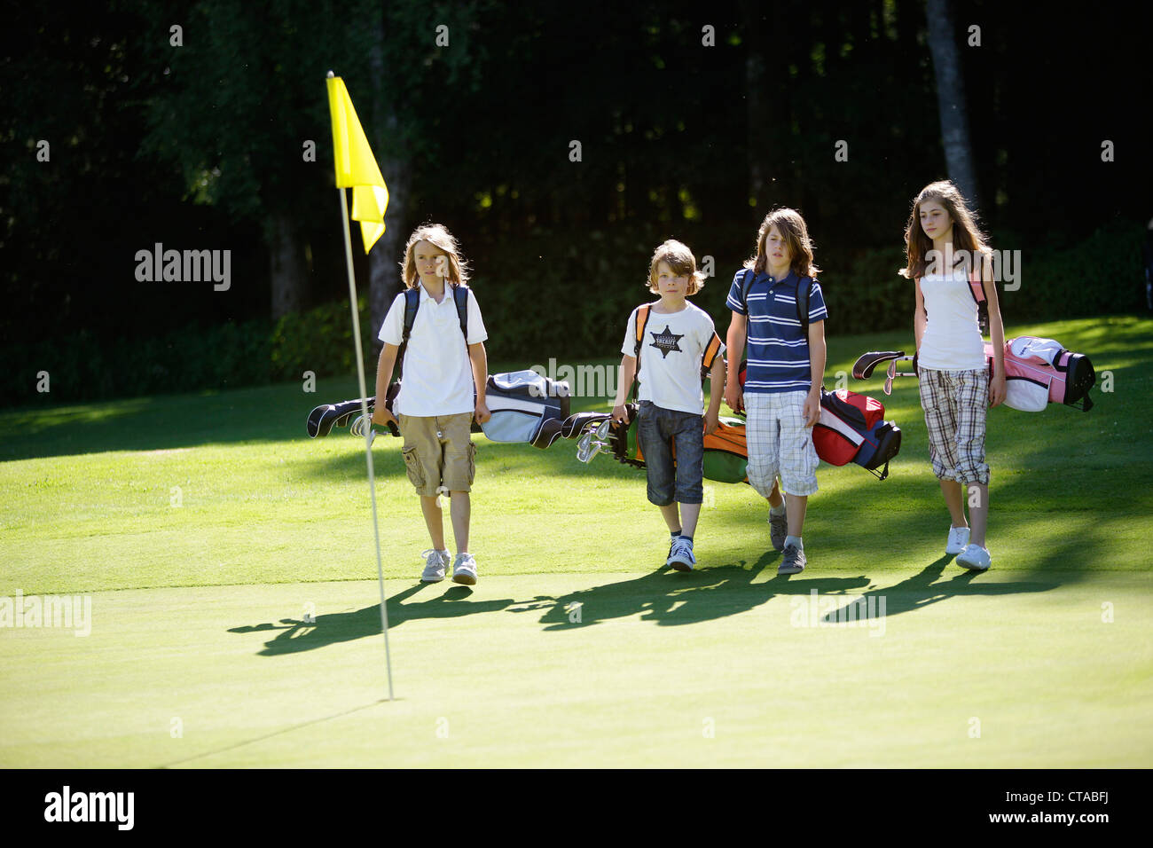 Children playing golf, Bergkramerhof, Bavaria, Germany Stock Photo
