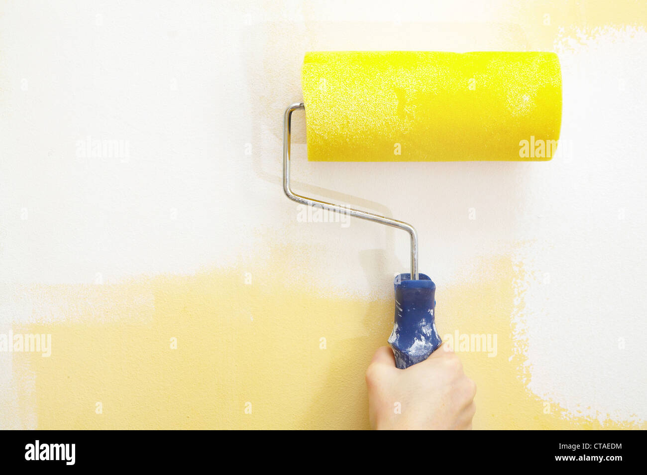 Paint roller on a wall... Stock Photo