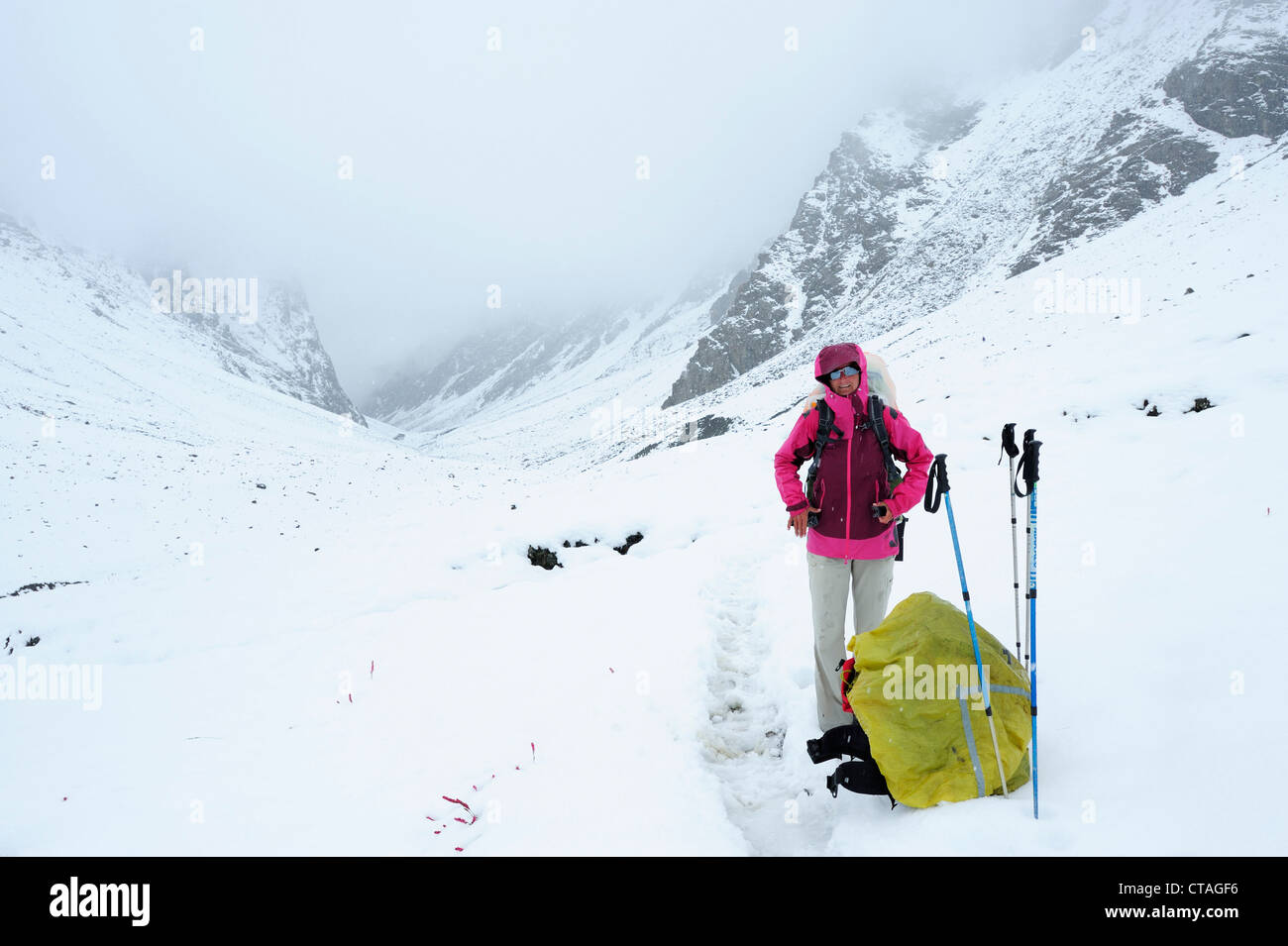 Woman standing on snow-covered path, Shingo La, Zanskar Range Traverse, Zanskar Range, Zanskar, Ladakh, Jammu and Kashmir, India Stock Photo