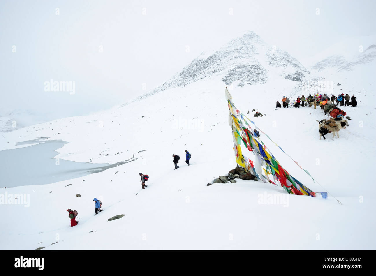 Monks, people and pack animals at snow-covered pass, Shingo La, Zanskar Range Traverse, Zanskar Range, Zanskar, Ladakh, India Stock Photo