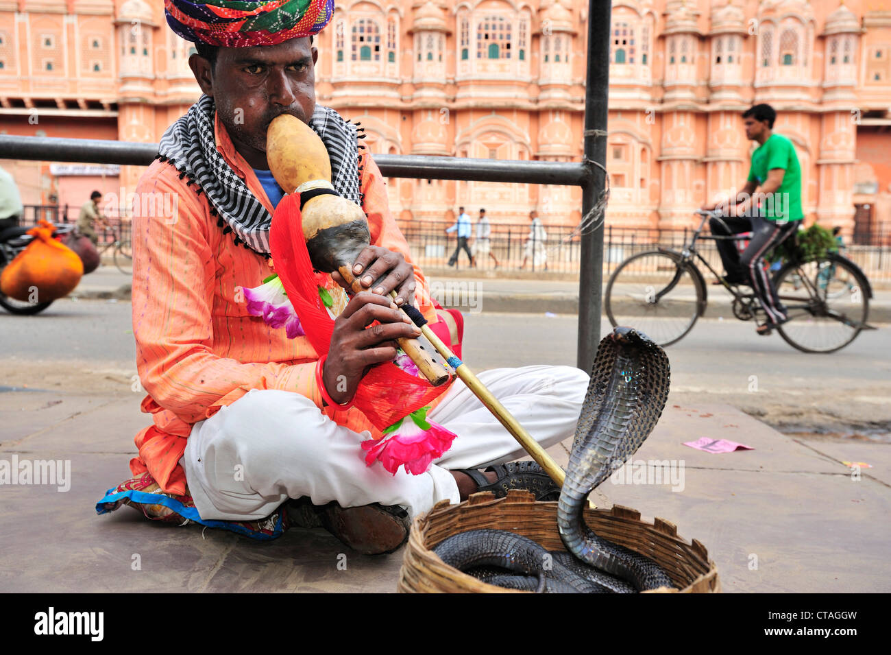 Snake charmer with palace of winds in background, palace of winds, Hawa Mahal, Jaipur, Rajasthan, India Stock Photo