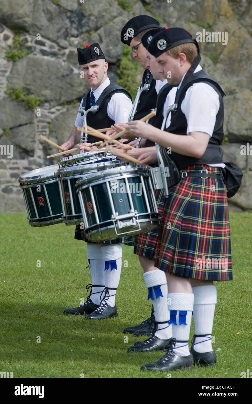 Three drummers of the Major Sinclair Memorial Pipe Band, on Gallows Green, Carrickfergus Castle. Stock Photo