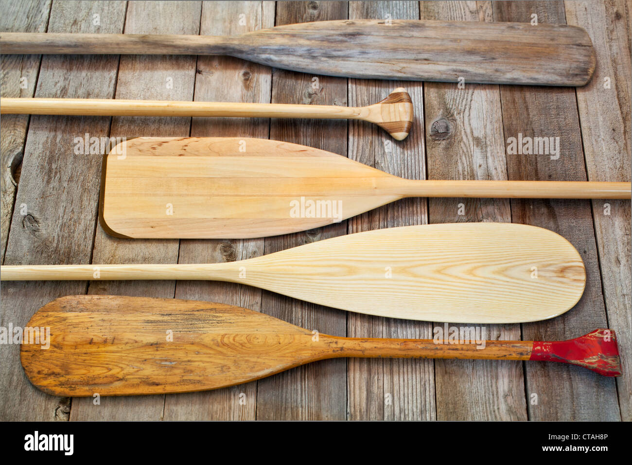 blades and grips of wooden canoe paddles of different shape against