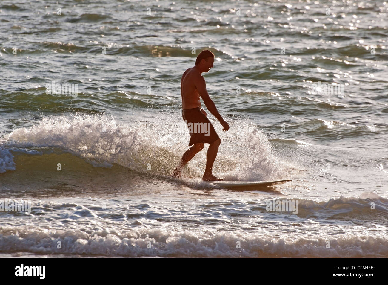Young surfer enjoying the late afternoon waters of the Gulf of Mexico at Naples Florida. Stock Photo