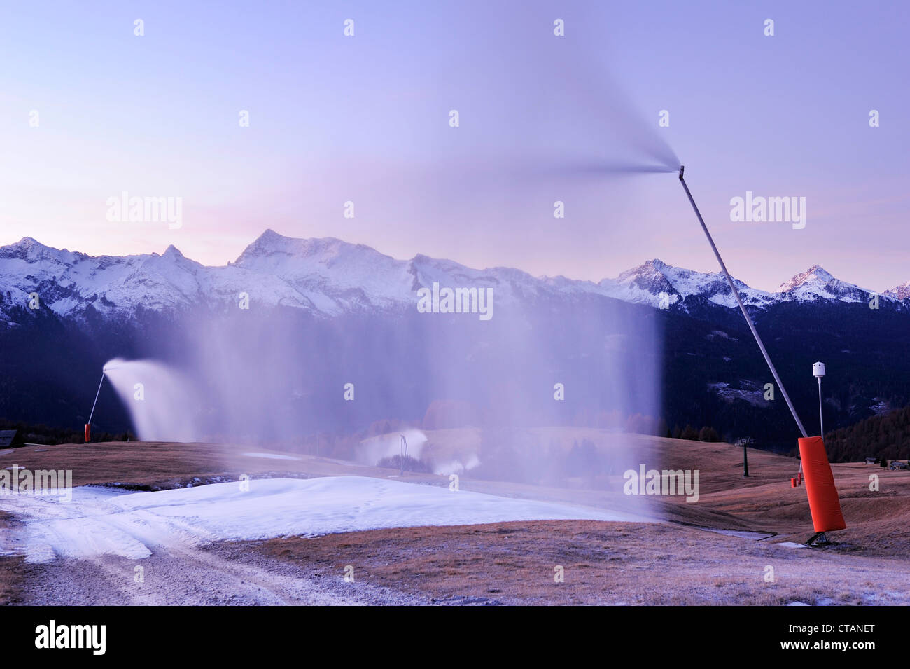 Snow cannons blowing artificial snow on slope, Lagorai range in background, valley of Fiemme, Dolomites, UNESCO World Heritage S Stock Photo