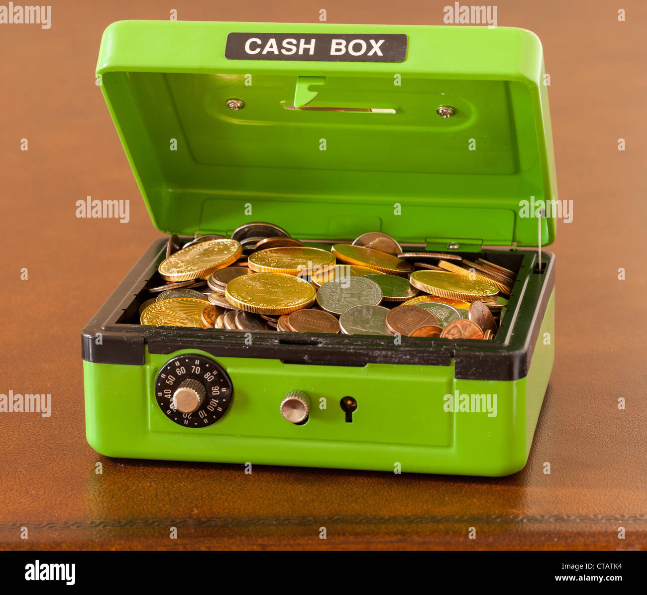Green cash box with combination lock open to show piles of coins