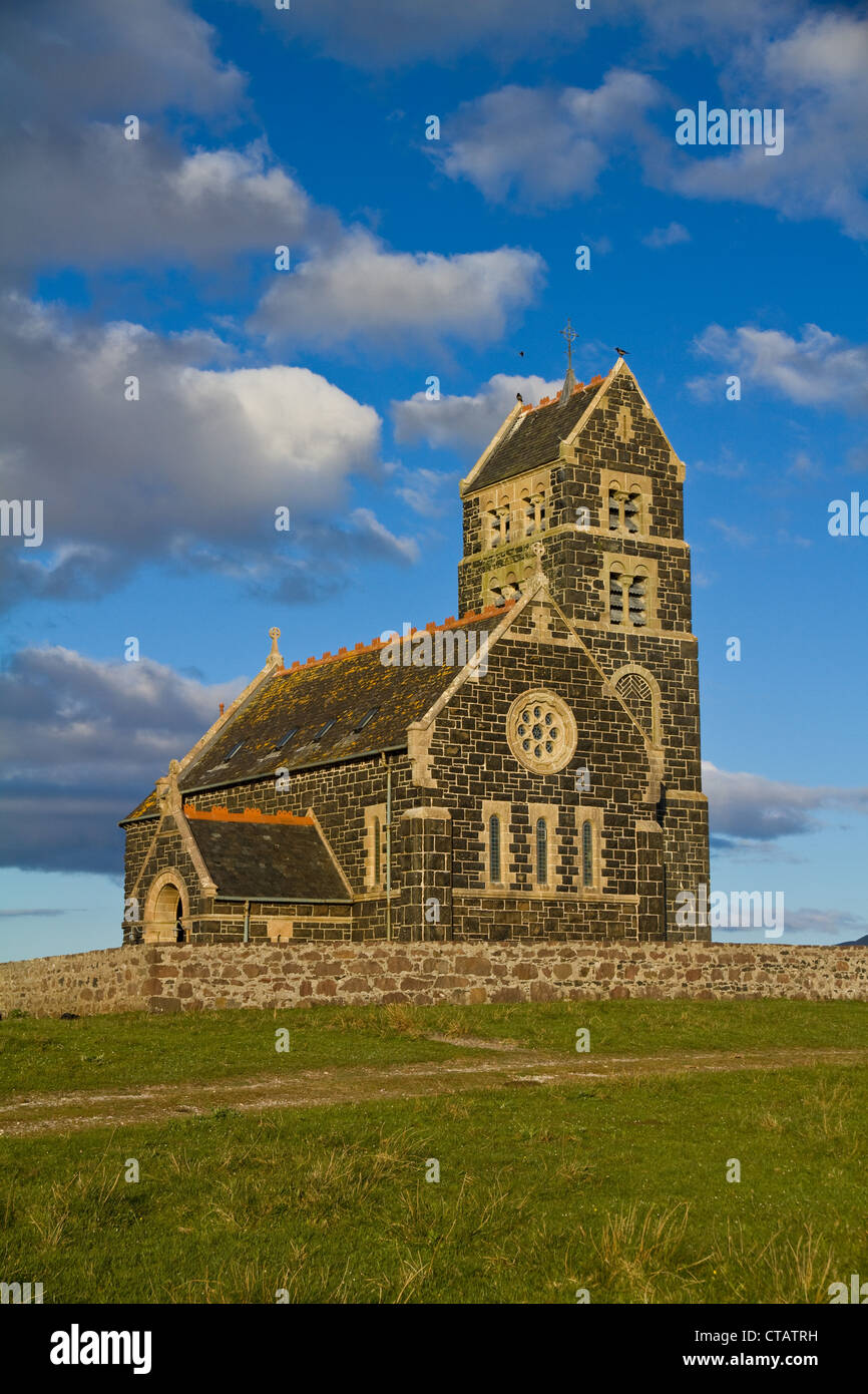 St Edward's Church on Sanday, Isle of Canna, Small Isles, Scotland, against a bright blue sky and white clouds Stock Photo