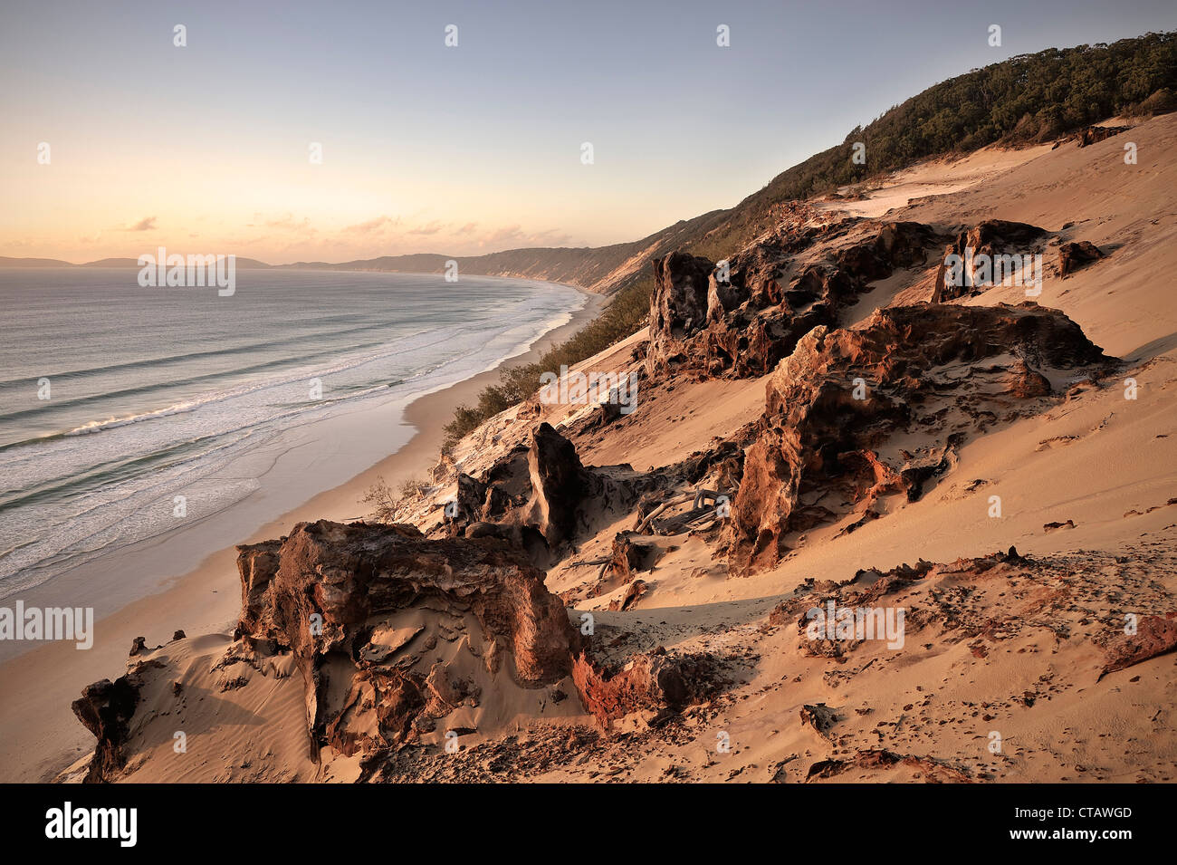 Sand dunes and rocks at Rainbow Beach at sunrise, Fraser Island, UNESCO World Nature Site, Southern Pacific, Queensland, Austral Stock Photo