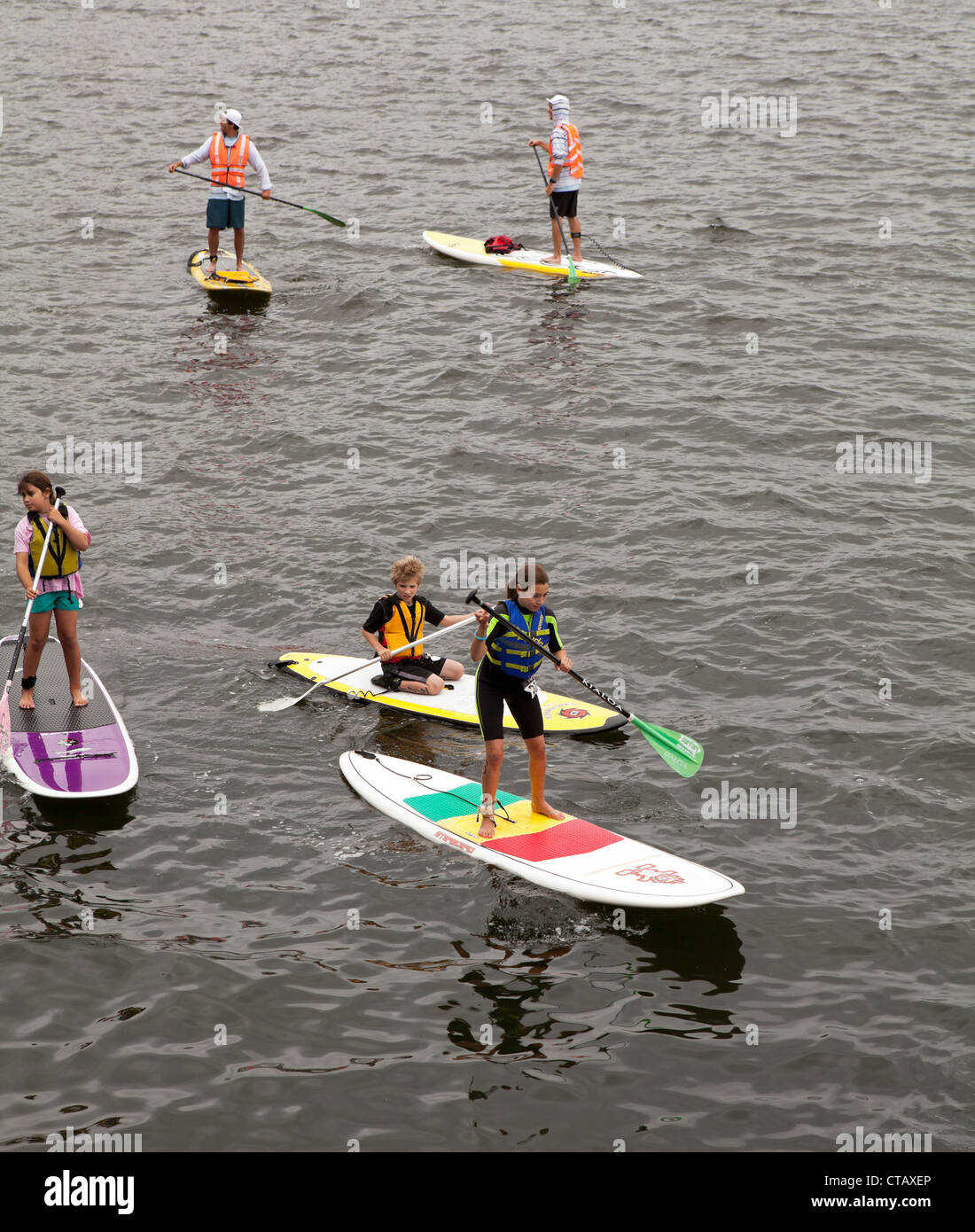 Kids practice their stand up paddle boarding in one of Boston's harbors