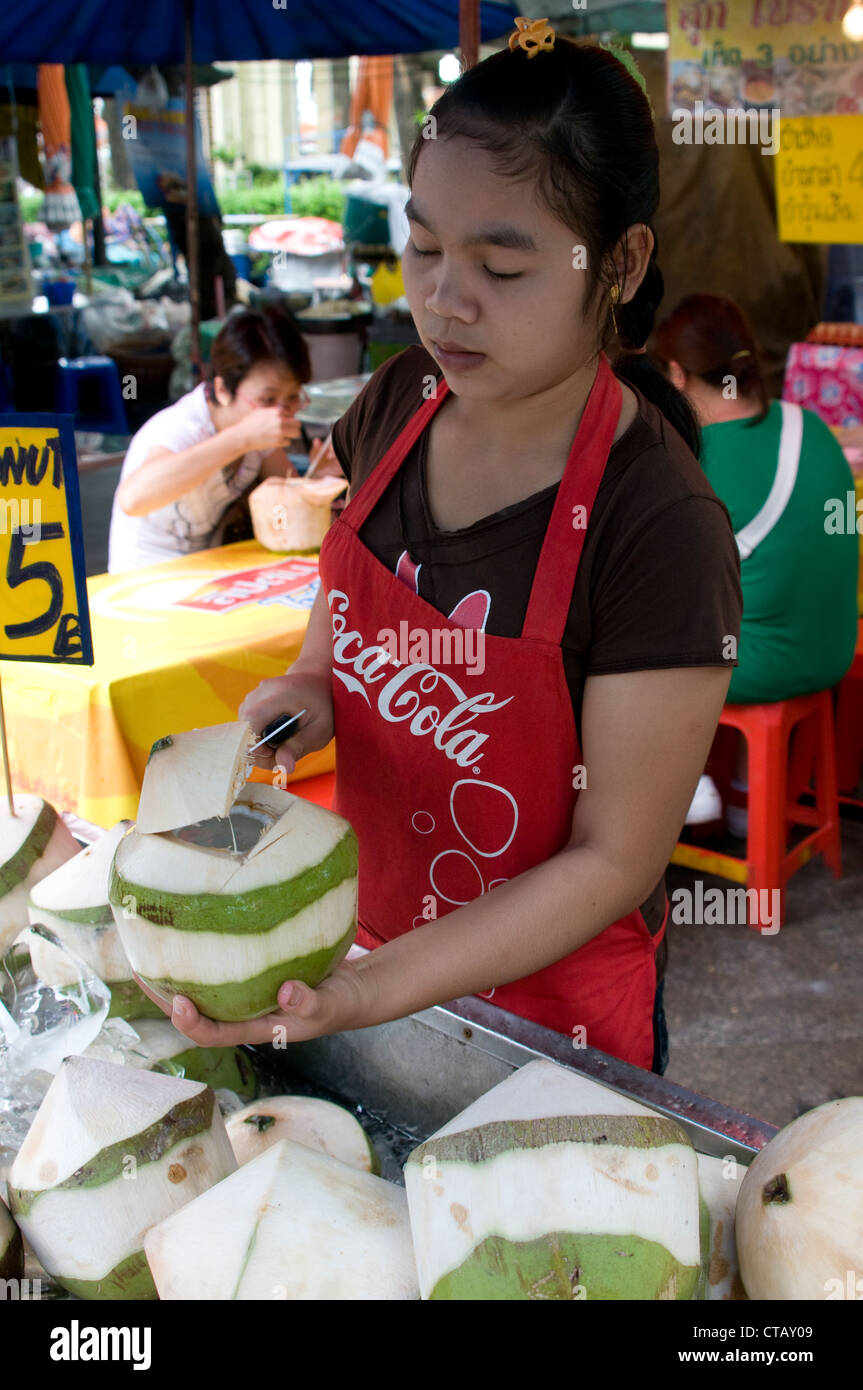 A food vendor hacking a coconut at a food stall in food market in Bangkok,Thailand. Stock Photo