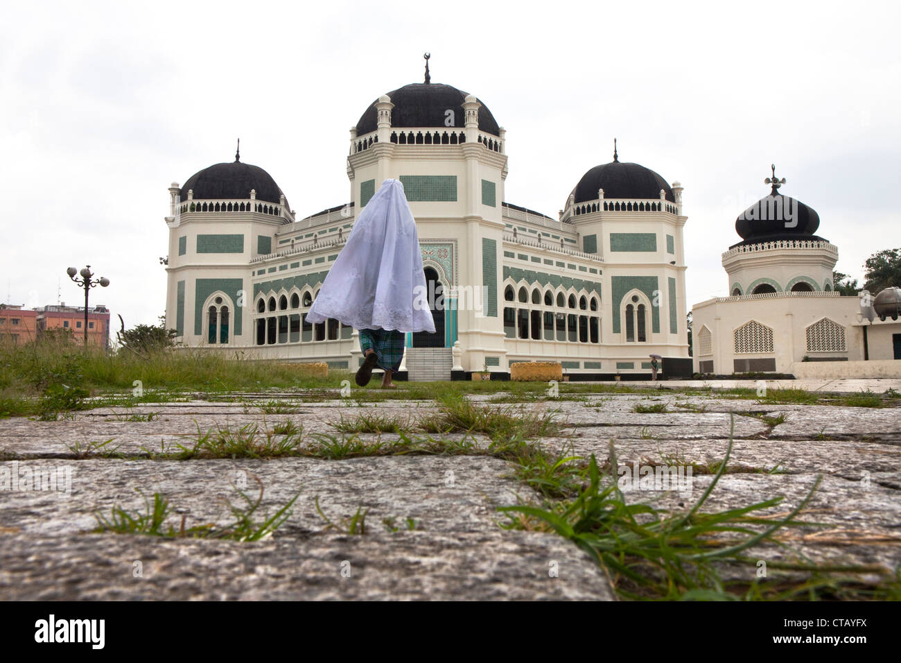 Muslim pilgrim in front oft he Grand Mosque in Medan, capital of Sumatra Utara province, Island of Sumatra, Indonesia, Southeast Stock Photo
