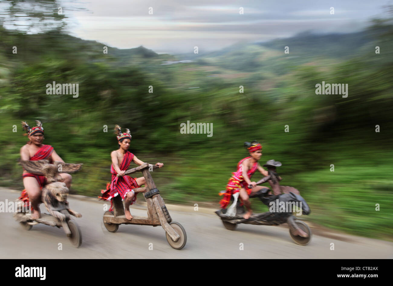 Ifugao men speeding on wooden scooters, Banaue, Ifugao, Luzon Island, Philippines Stock Photo