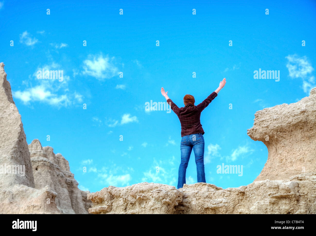 Woman with raised hands against blue sky Stock Photo - Alamy