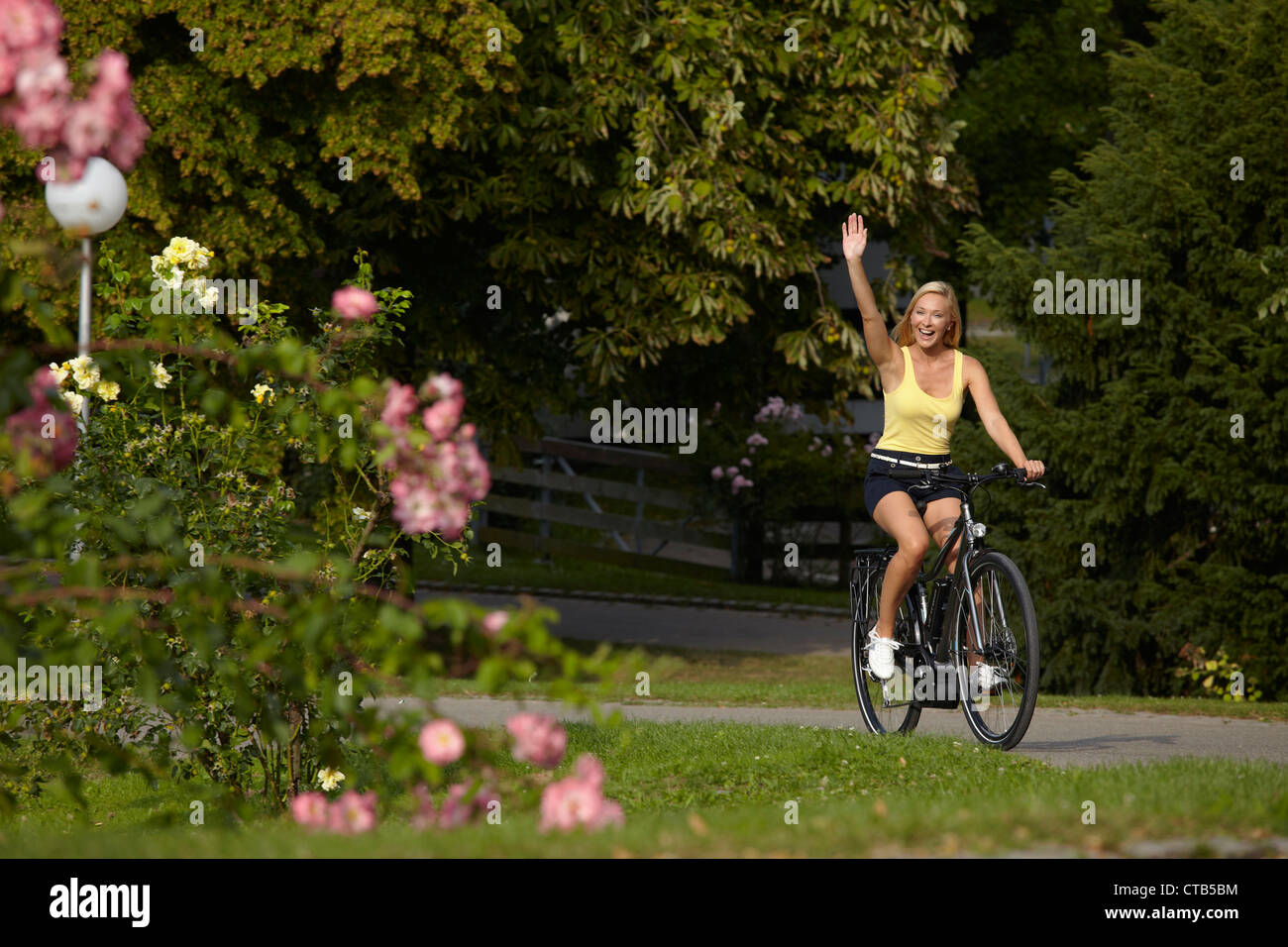 Woman biking through the castle gardens on an E-Bike, bike tour, e-bike, Lower Castle Garden, Stuttgart, Baden-Wurttemberg, Germ Stock Photo