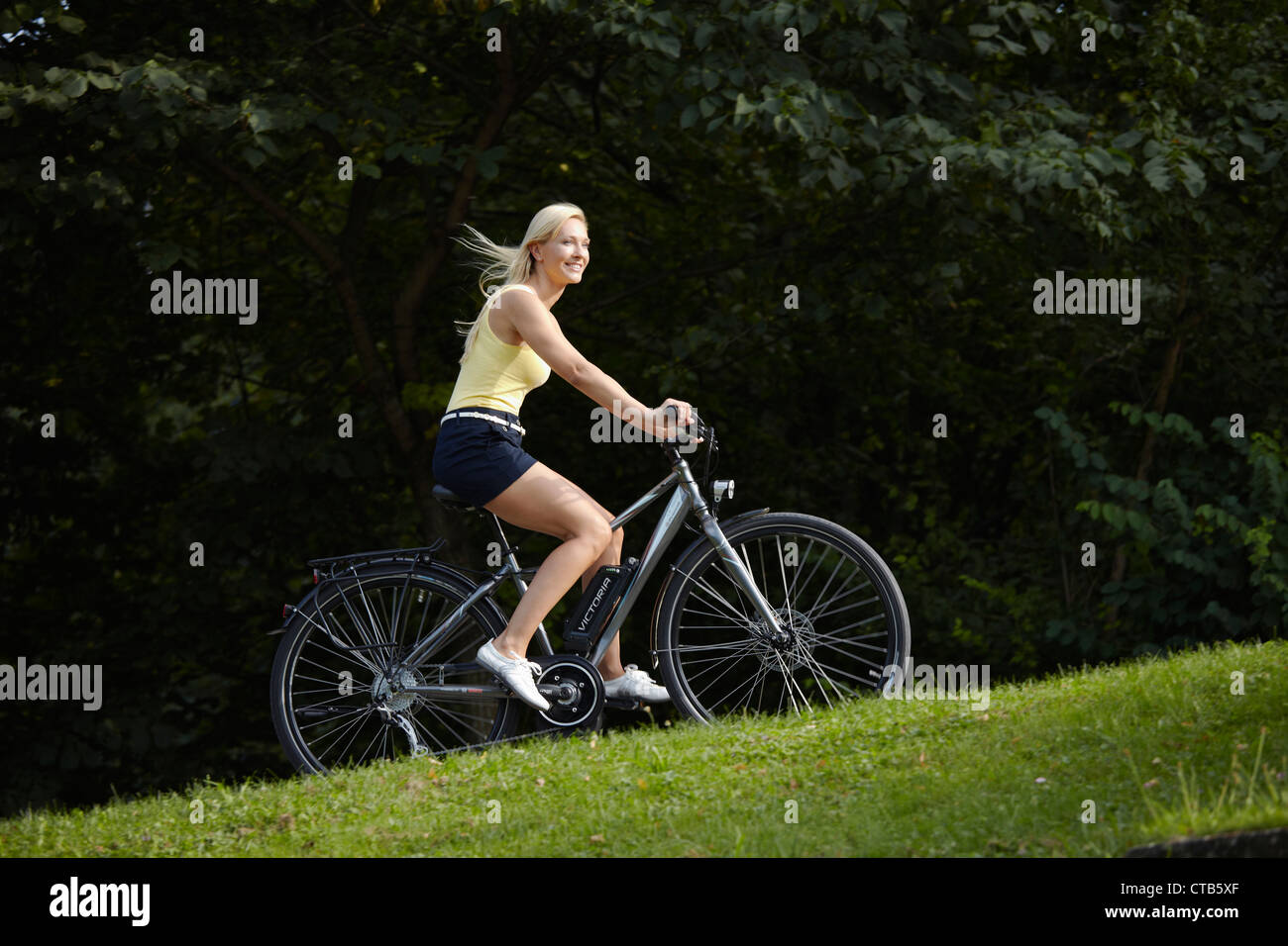 Woman biking through the castle gardens on an E-Bike, bike tour, e-bike, Lower Castle Garden, Stuttgart, Baden-Wurttemberg, Germ Stock Photo