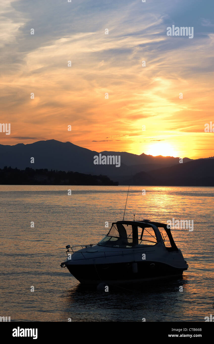 Small yacht anchored in quite lake water before the dawn; Maggiore Lake, Italy. Stock Photo
