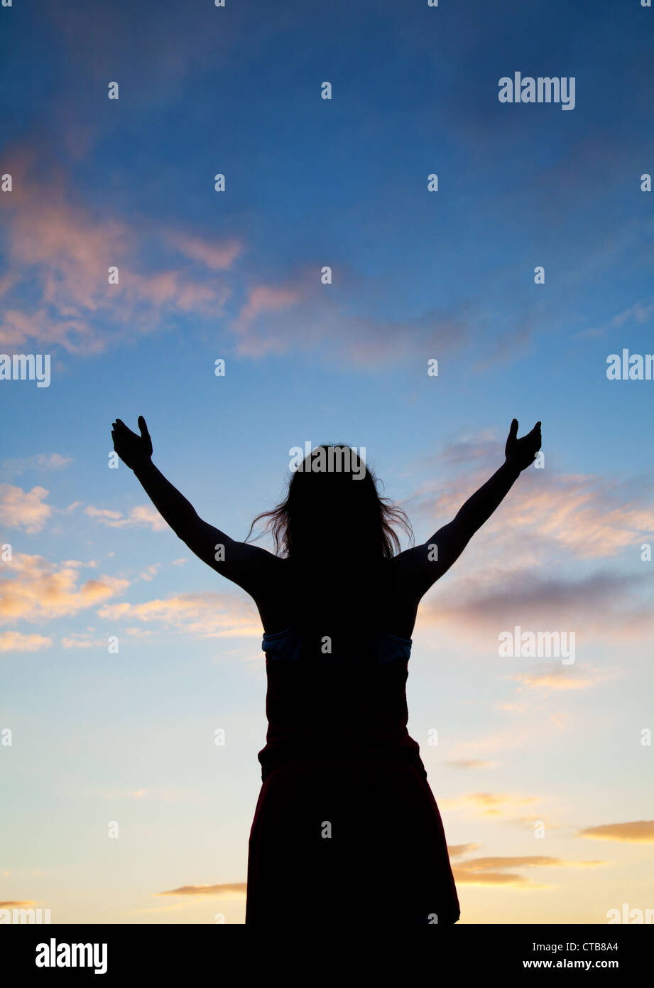 Woman staying with raised hands at the sunset time Stock Photo - Alamy