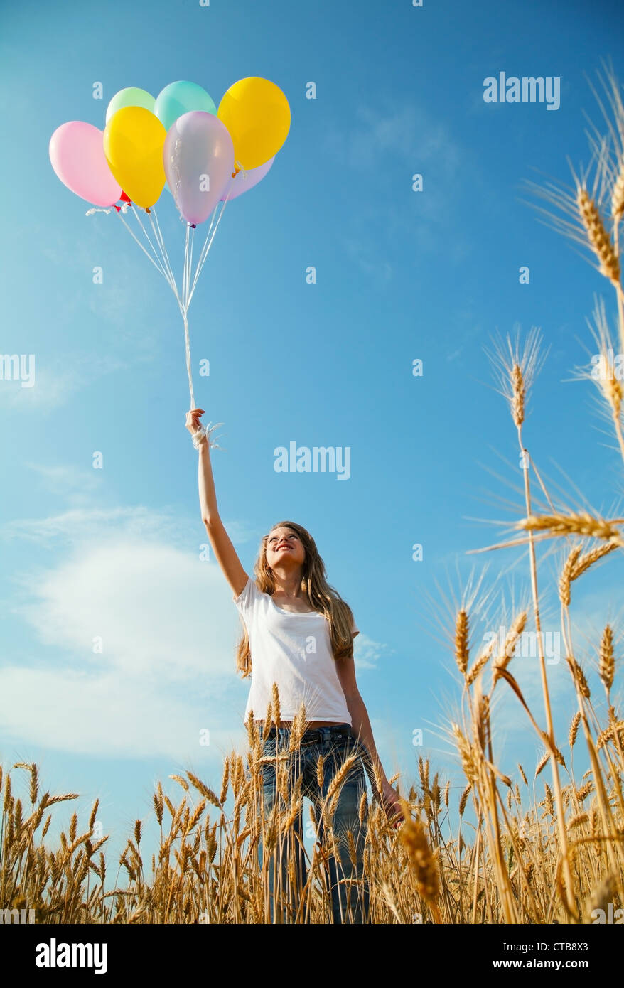 Teen girl at a wheat field with colorful balloons Stock Photo - Alamy