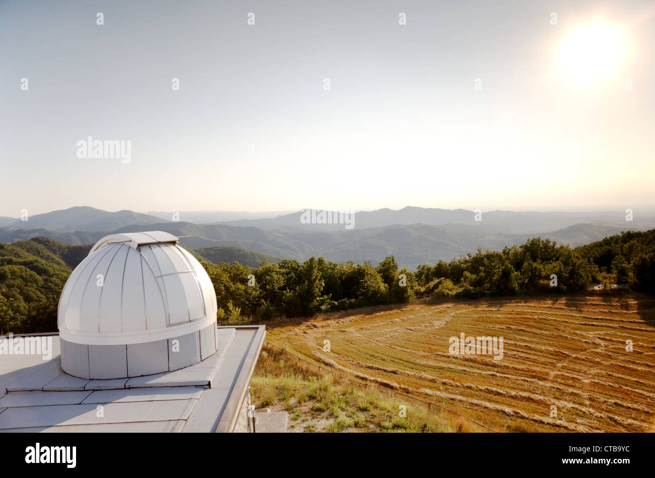 White dome of a small astronomical observatory on the top of a hill in